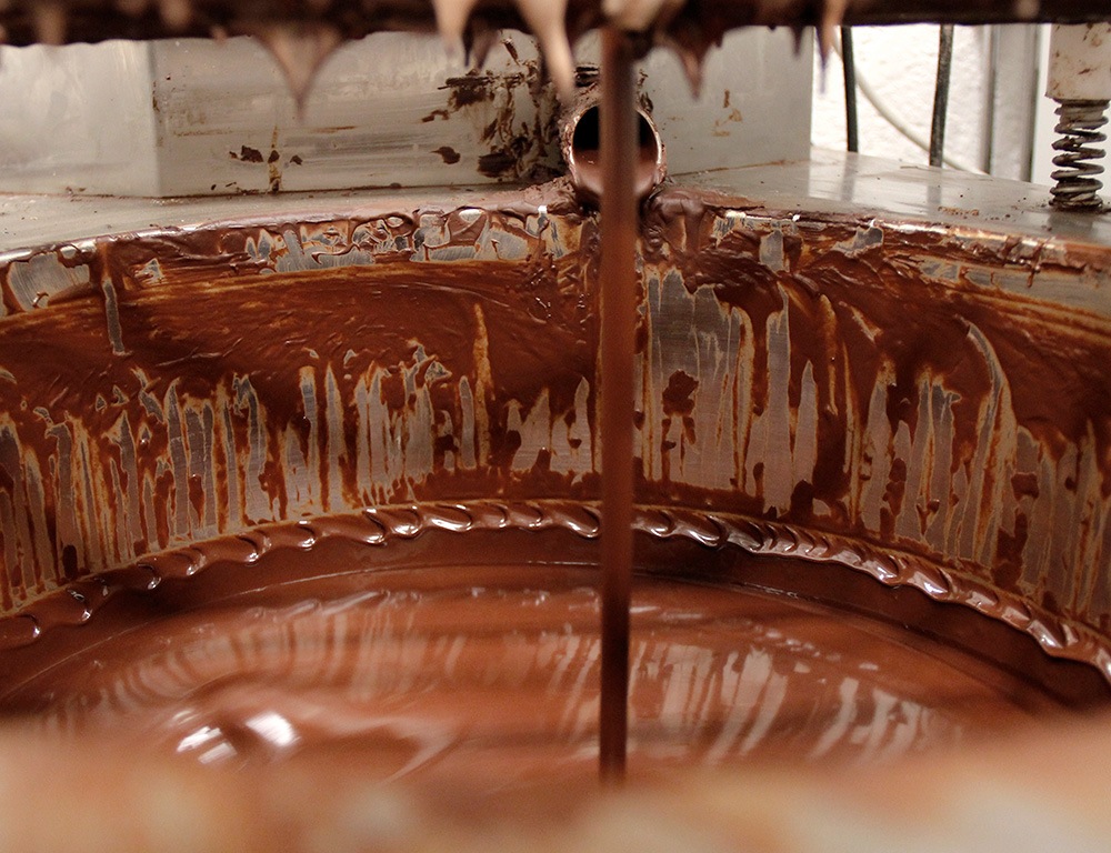 Choklad som rinner och samlas upp i en bunke.