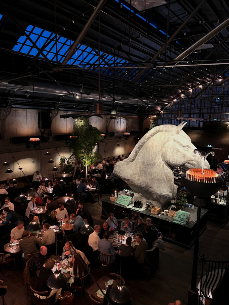 En bild inne i Tavolos restaurang. Folk äter vid olika bor. 