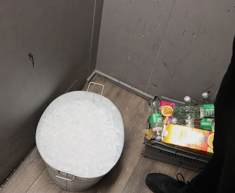 I hissen står det en bunke med is samt en låda med juice och sprite.