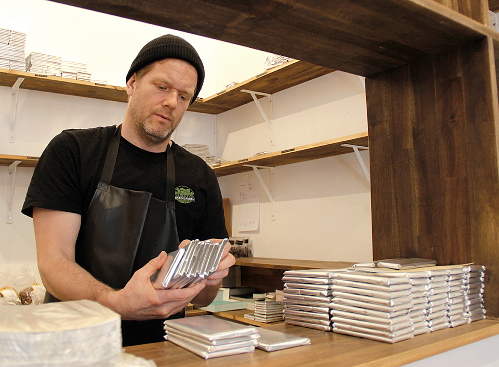 Bild på Johan som håller chokladkakor paketerade i silverförpackning i handen 