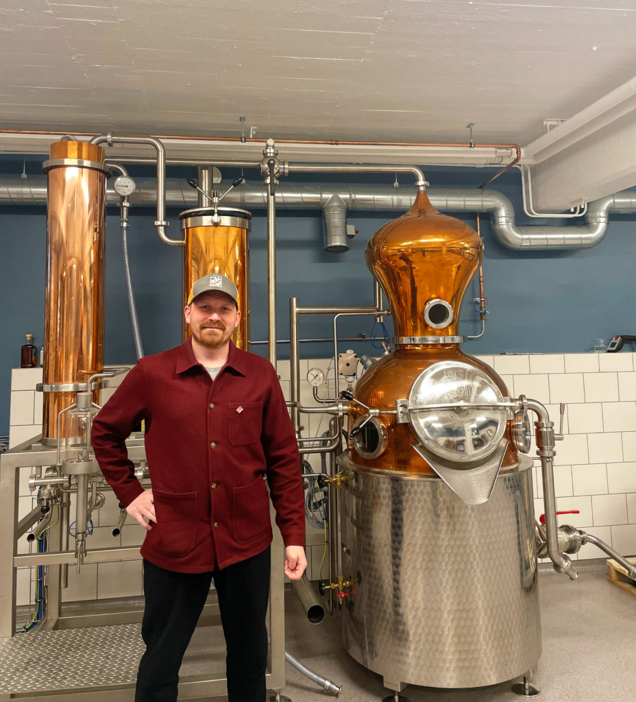 Viktor Lorén framför destilleringsapparaten.